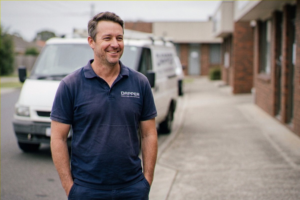 Dapper team member beside the work van